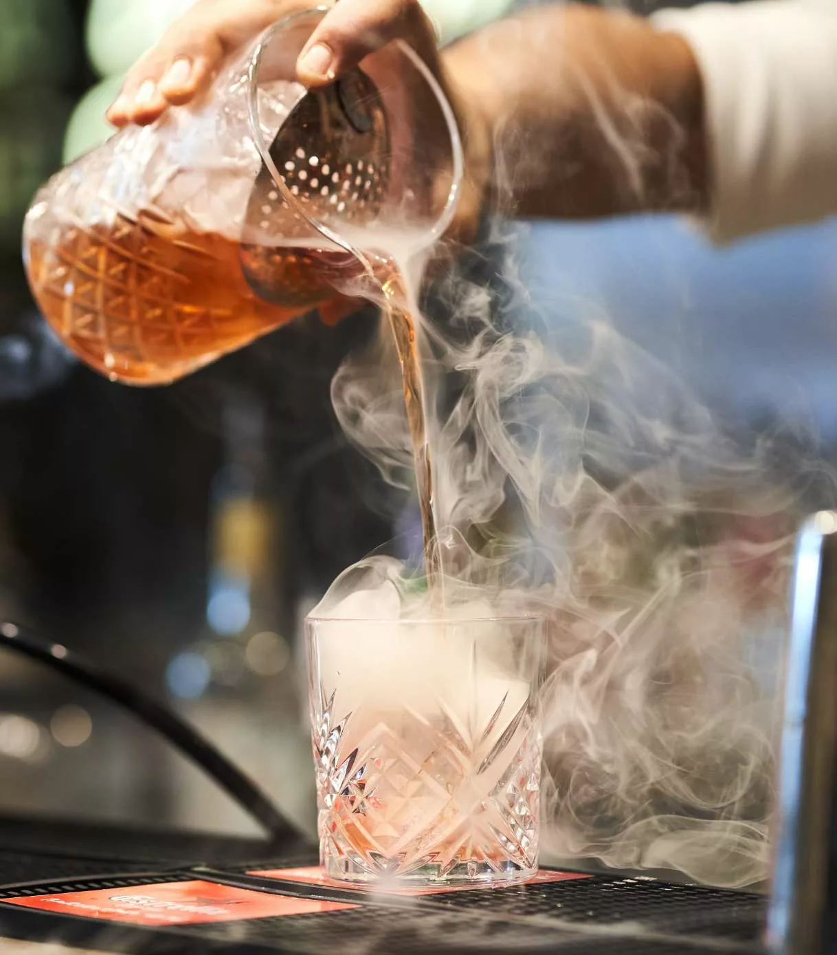 Zoomed in shot of a mixologist preparing a cocktail.