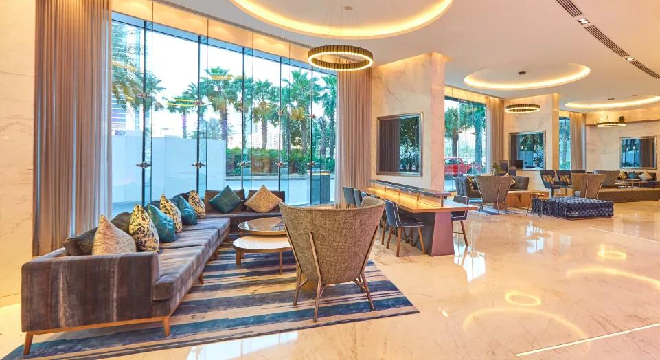 Media One Hotel lobby showcasing comfortable chairs situated next to a large window with natural light.